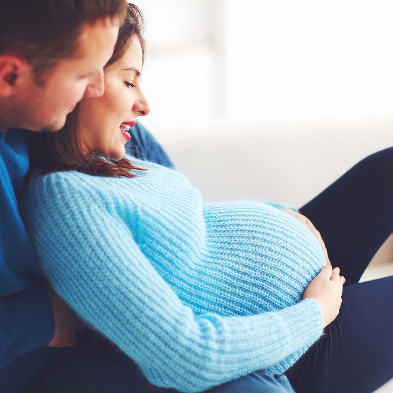 Happy parents holding woman's baby bump